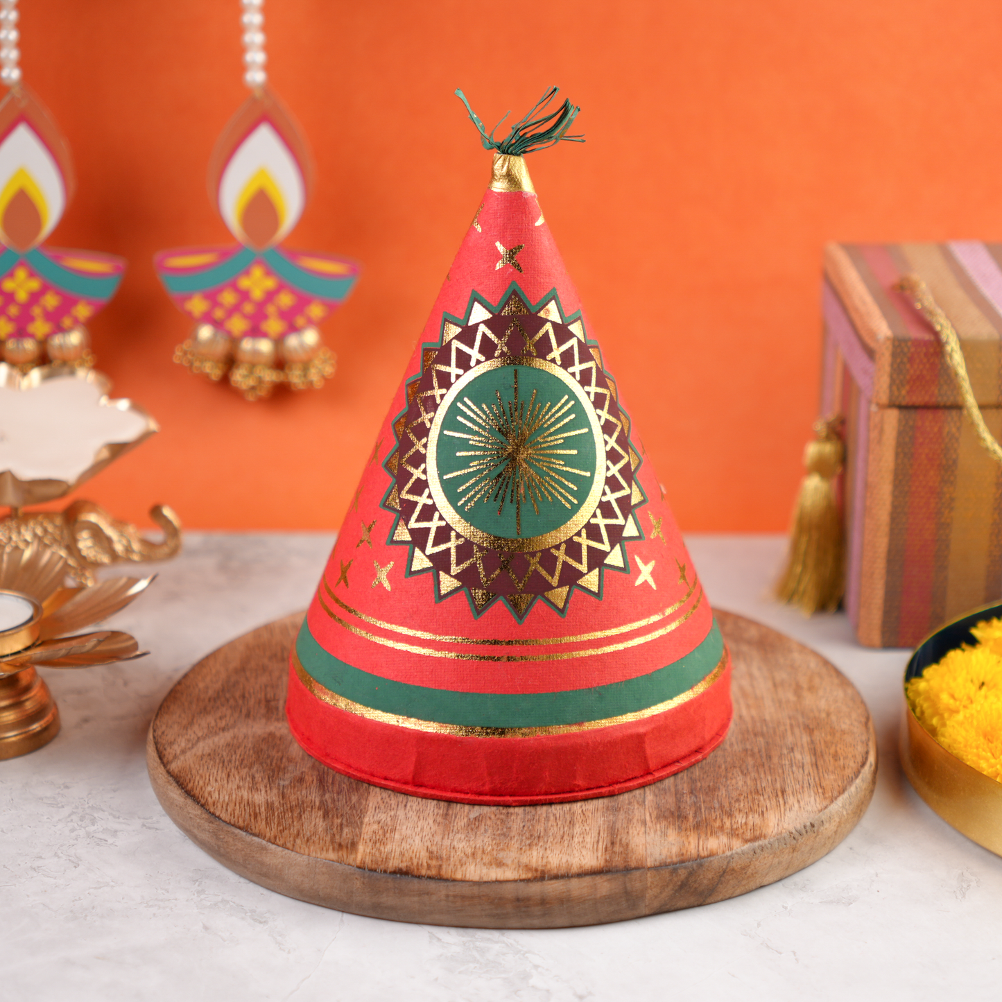 Diwali Ka Anaar Gift Box closed cracker-shaped keepsake with red and gold festive artwork and golden ribbon.