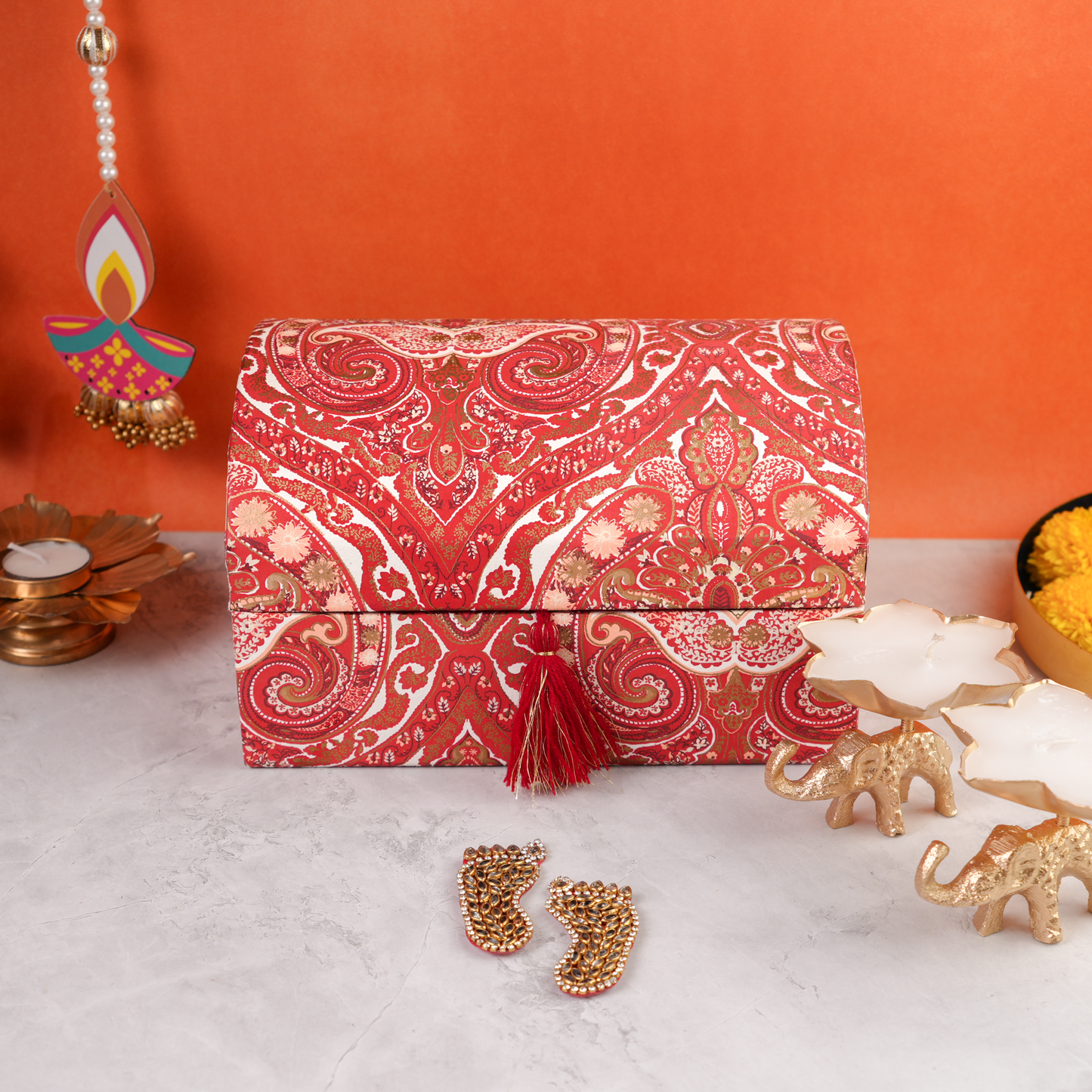 Closed Paisley Celebration Sandook Box with red paisley fabric, golden tassel closure, and festive detailing styled for Diwali gifting.