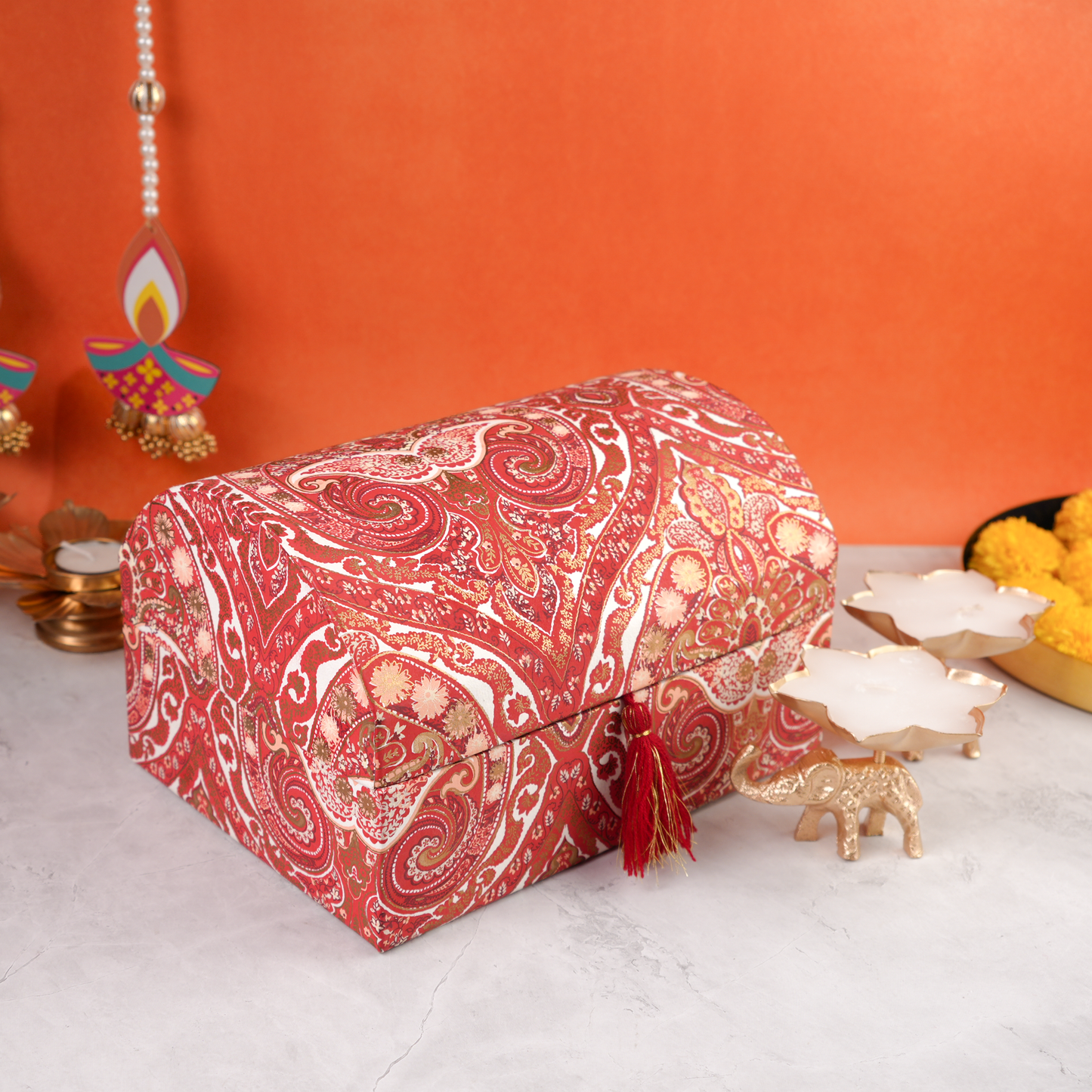 Side angled closed Paisley Celebration Sandook Box with intricate red paisley pattern, tassel accent, and decorative festive styling.