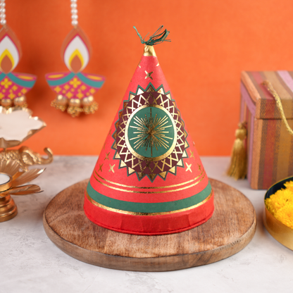 Diwali Ka Anaar Gift Box closed cracker-shaped keepsake with red and gold festive artwork and golden ribbon.