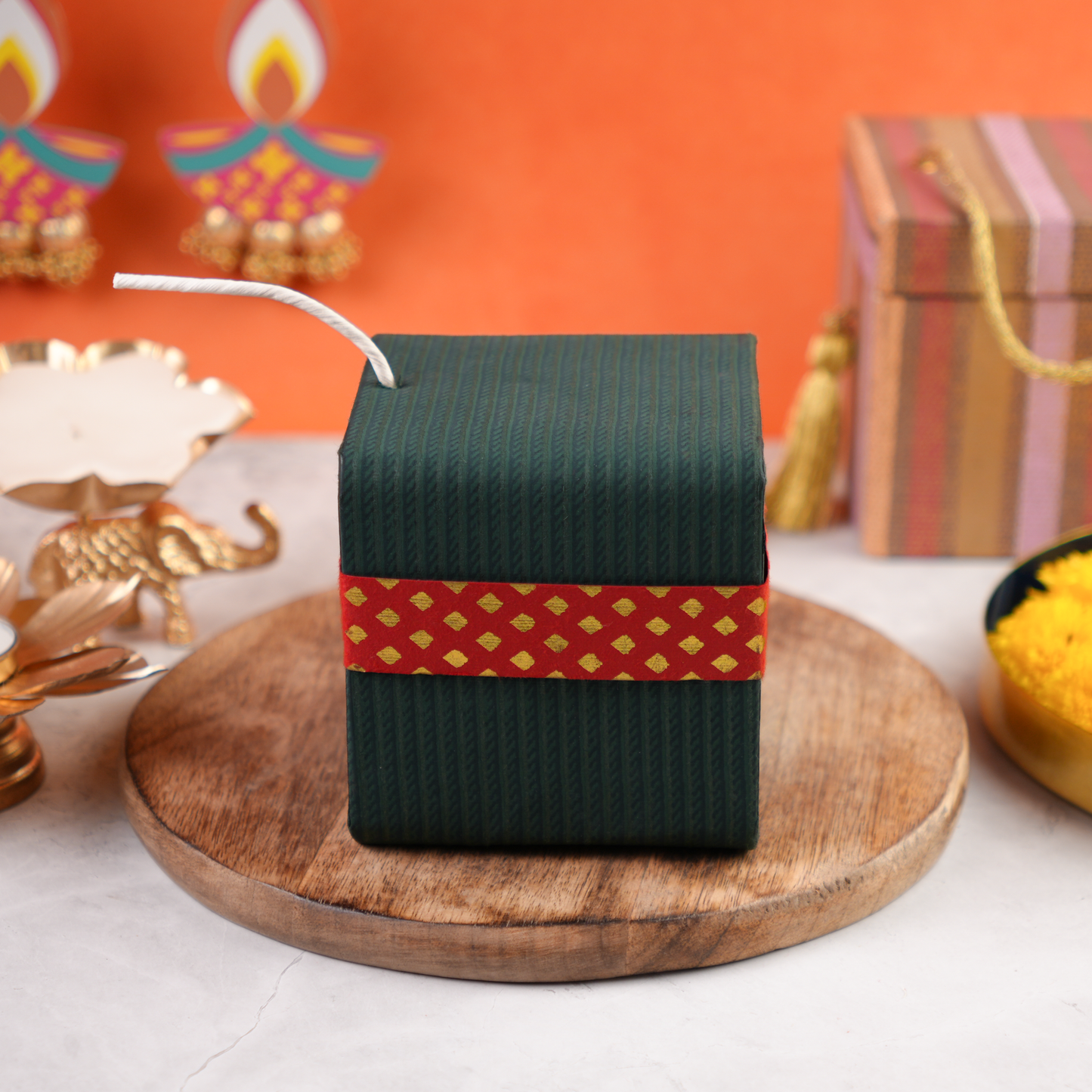 Closed green Sutli Dhamaka Diwali gift box with red festive band and white fuse, cracker-inspired keepsake design.