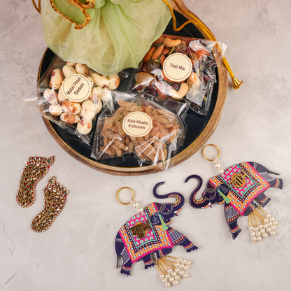 Festive Potli Gift Pack open display – green organza potli opened to reveal assorted festive dry fruits, diwali accents and treats.