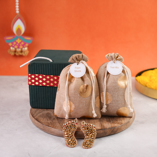 Open Sutli Dhamaka Diwali gift box with cracker-inspired design, displayed alongside festive jute potlis and decorative Laxmi Charan.