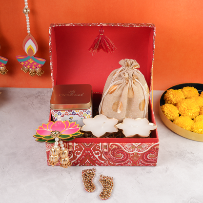 Front display of Paisley Celebration Sandook Box showcasing golden drawstring potli, premium Octavius tea tin, lotus candles, and festive lotus dangler.