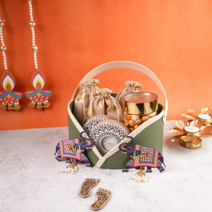Premium pastel green Diwali gift basket with golden pouches, jar of snacks, tealight holder, and festive decor accents