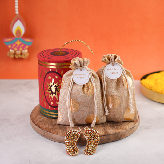 Rangeela Chilly Bomb festive gift box with two golden potli bags and decorative embellishments on a wooden base for Diwali gifting.