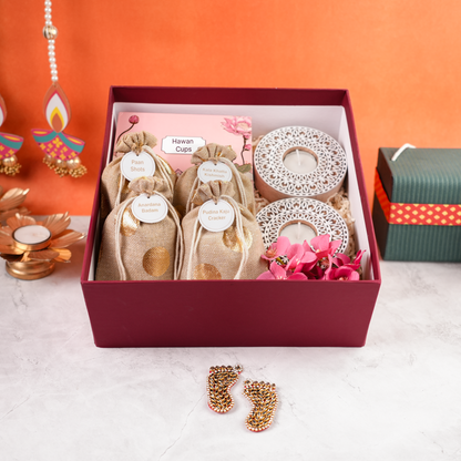Open Ruby Royale hamper showing four jute potlis, tealight holders, and festive fillers, top view.