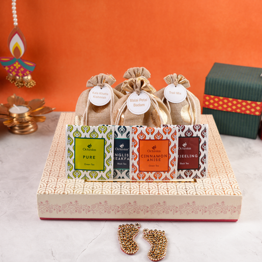 Assorted tea sachets displayed with three jute potlis atop the cream-gold Diwali box