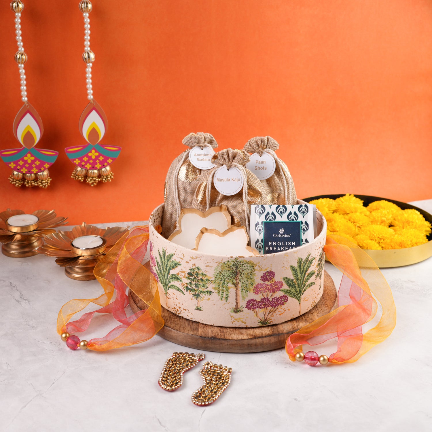 Open Vanmahal Diwali Hamper round gift box with festive jute potlis, tealight candles, and tea packs styled for Diwali gifting.